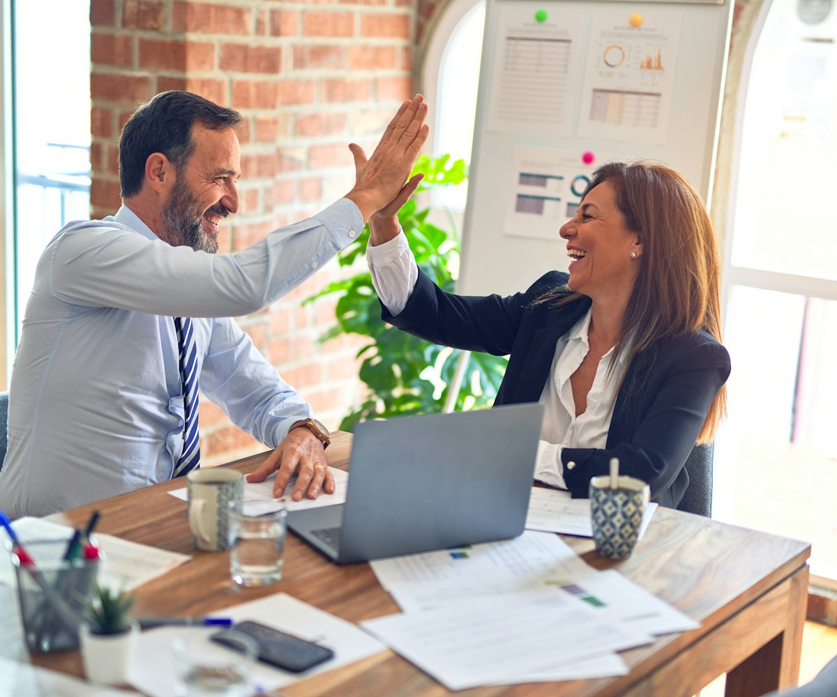 Two advisers celebrating a completed mortgage with a client